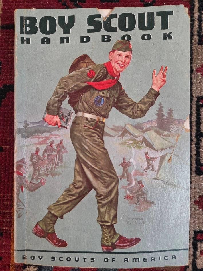 Cover of a vintage Boy Scout Handbook shows a smiling scout in uniform carrying a backpack, saluting as he walks. Illustrated scouts, tents, a campfire, and trees are in the background. Title reads “Boy Scout Handbook. Boy Scouts of America.”.